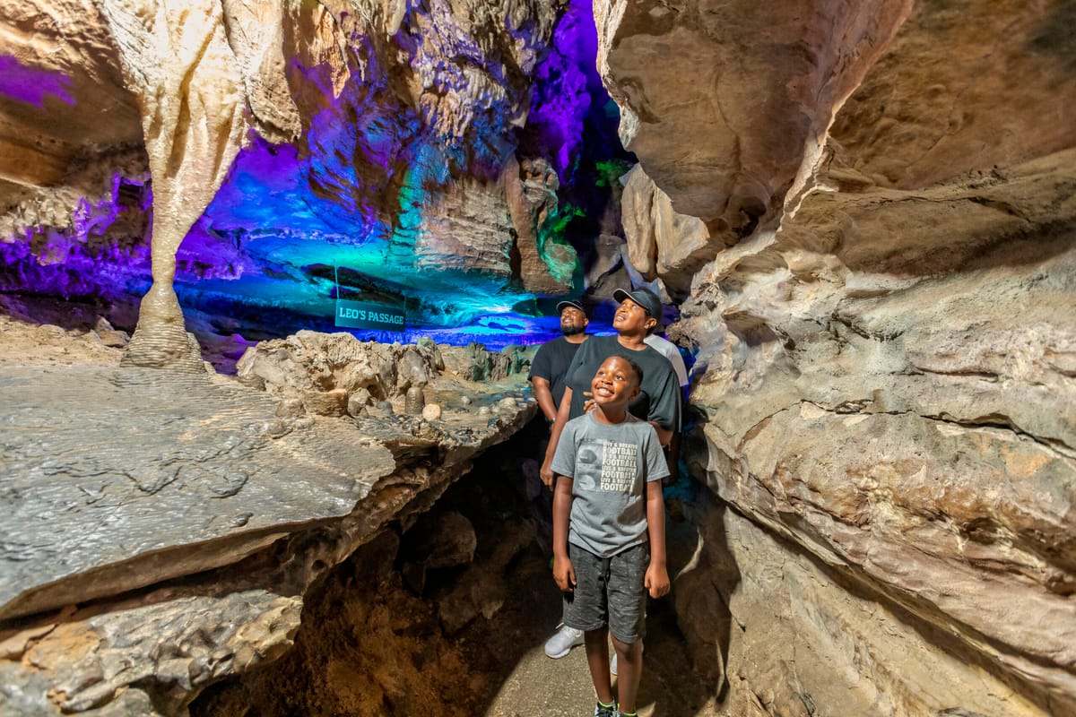 A family walks admiring the caves next to a sign reading
